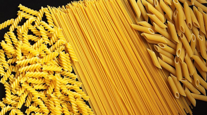 various-types-of-uncooked-pasta-on-black-counter